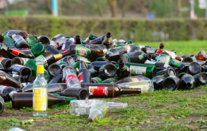 Tasche gefüllt mit leeren Getränkedosen, Plastik- und Glasflaschen vor fahrendes Auto geschleudert