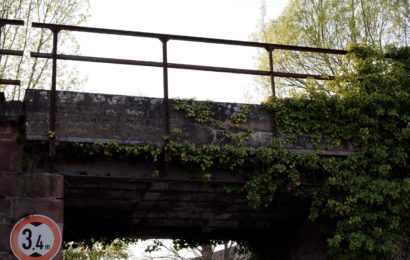 Aufbaukran nicht eingefahren und an Bahnbrücke hängengeblieben