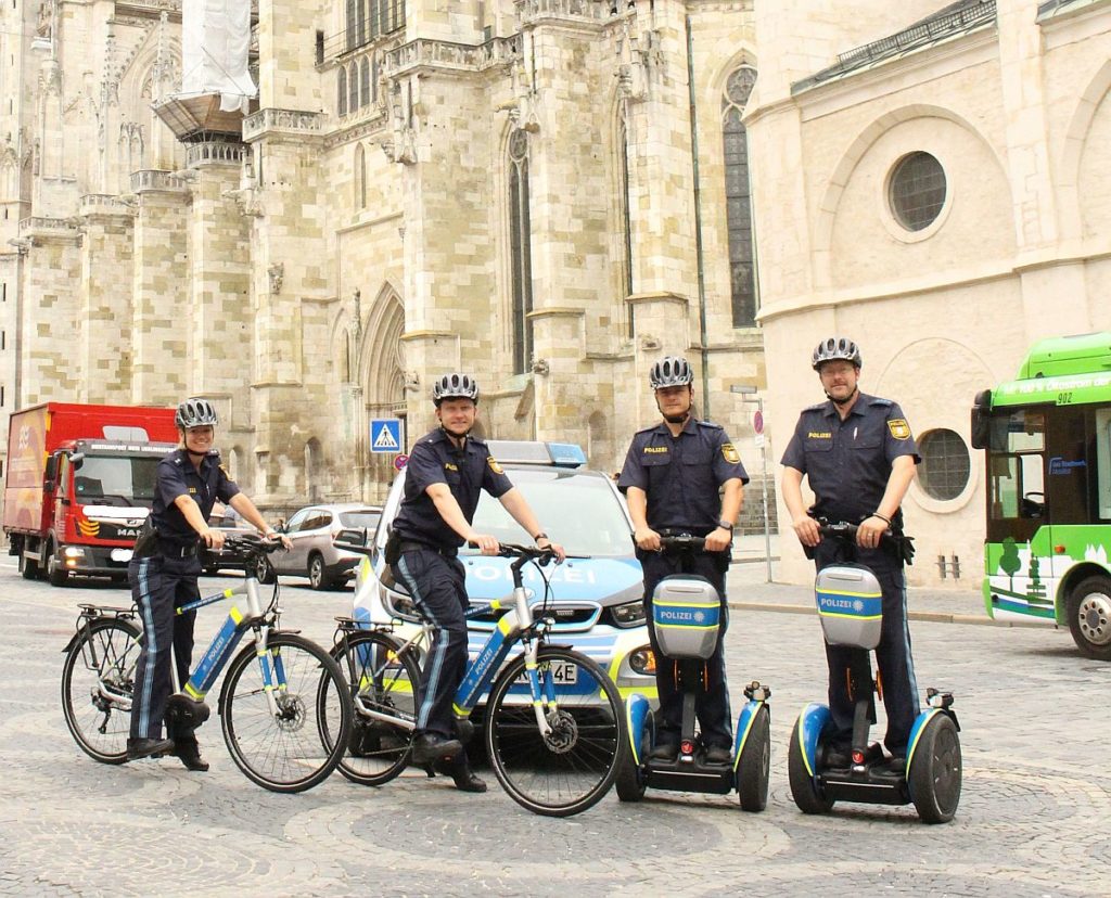 Polizeibeamte der PI Regensburg Süd mit den der Dienststelle zur  Verfügung stehenden Elektrofahrzeugen (Lichtbild: PI Süd)