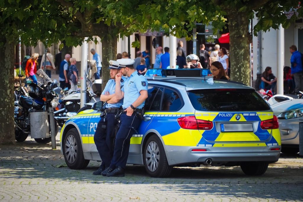 Symbolbild: Polizisten mit Streifenwagen