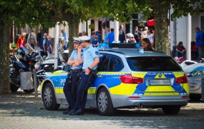 Symbolbild: Polizisten mit Streifenwagen