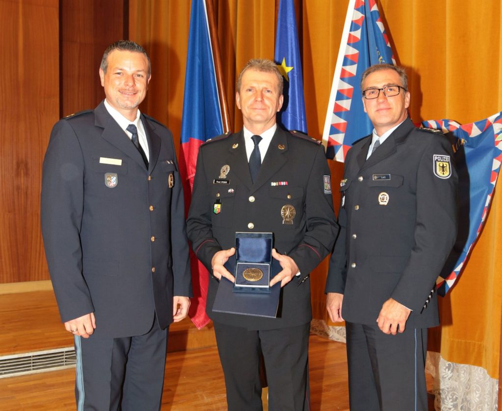 Im Bild: Der deutsche Koordinator des GZ, Polizeioberrat Christian Kiener (links), nimmt in Pilsen zusammen mit Major Pavel Rybar (Mitte), Kontingentsleiter der Tschechischen Polizei, und Erster Polizeihauptkommissar Markus Leitl (rechts) die Medaille des Polizeipräsidenten der Tschechischen Republik für Verdienste in der internationalen Zusammenarbeit entgegen. Bild: tschechische Polizei, für den Artikel freigegeben.