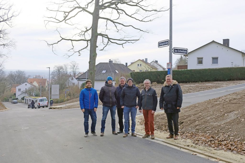 Oberbürgermeister Michael Cerny (rechts) und die Baufachleute (v.l.n.r.)  Markus Herrmann und Dieter Imhof (städtisches Tiefbauamt), Erwin Grill  und Markus Schmidt (Firma Mickan) sowie Rainer Rubenbauer (UTA  Ingenieure) freuten sich über die Fertigstellung der  Bauarbeiten in der Steingutstraße mit Anbindung der Straße Am  Eichenhain und der Laßlebenstraße (im Hintergrund)  Foto Susanne Schwab, Stadt Amberg 