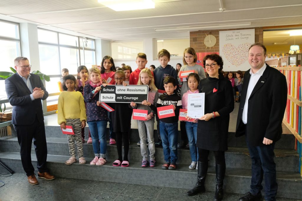 Regionalkoordinator  Thomas Vitzthum (rechts), Schulleiterin Marion Weigl (2.v.r.) und  Projektpate Oberbürgermeister Michael Cerny (links) freuen sich zusammen  mit den Schülerinnen  und Schülern sowie den Lehrkräften über den Titel "Schule ohne  Rassismus - Schule mit Courage", den die Albert-Schweitzer-Schule als  erste Grundschule in der Oberpfalz tragen darf. Foto: Susanne Schwab, Stadt Amberg