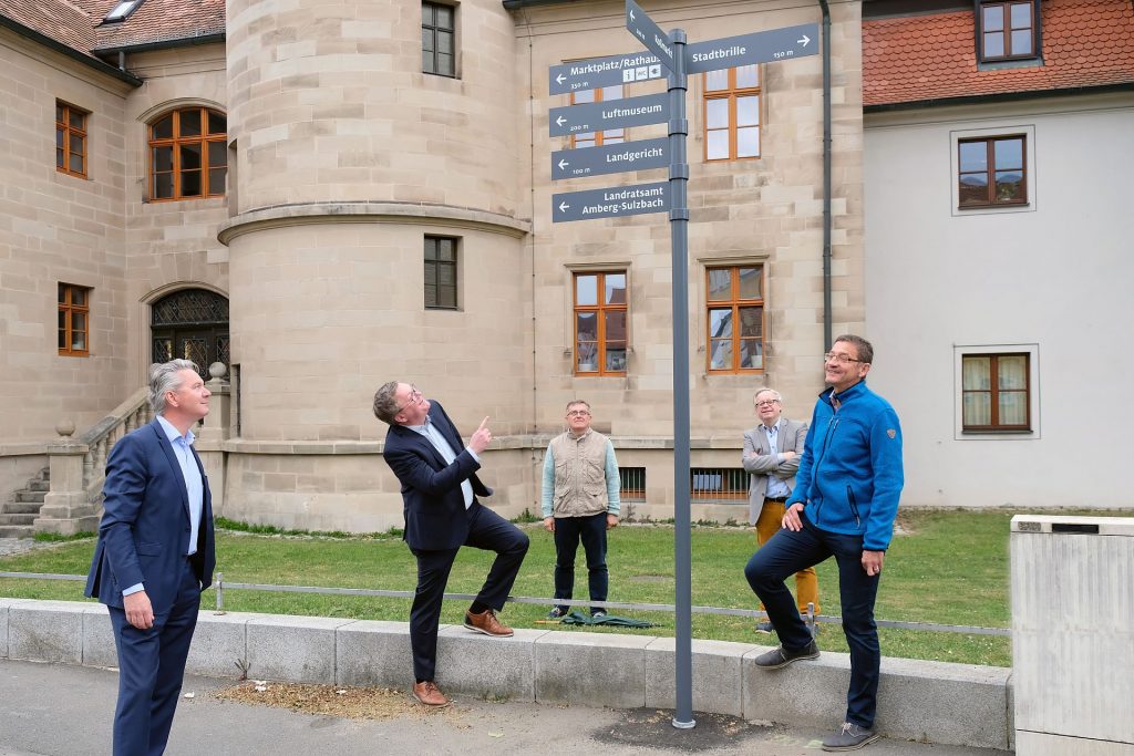 Baureferent Markus Kühne, Oberbürgermeister Michael Cerny, Tiefbauamtsleiter Norbert Füger, Kultur- und Tourismusreferent Dr. Fabian Kern und Kulturamtsleiter Reiner Volkert (v.l.n.r.) an einem der neu installierten Wegweiser des neuen Fußgängerleitsystems am Schlossgraben. Foto: Susanne Schwab, Stadt Amberg