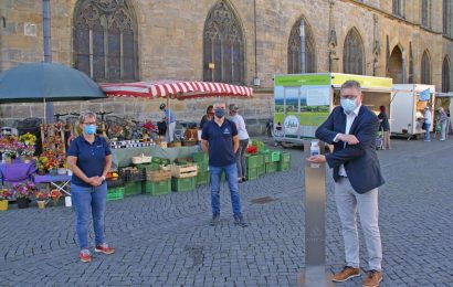 Oberbürgermeister Michael Cerny geht mit gutem Beispiel voran: Er nutzt mit Amtsleiterin Elisabeth Keck (links) und Lothar Thumbeck (mitte) vom Amt für Ordnung und Umwelt den Desinfektionsspender auf dem Marktplatz. Foto © Stadt Amberg, Ina Bogner