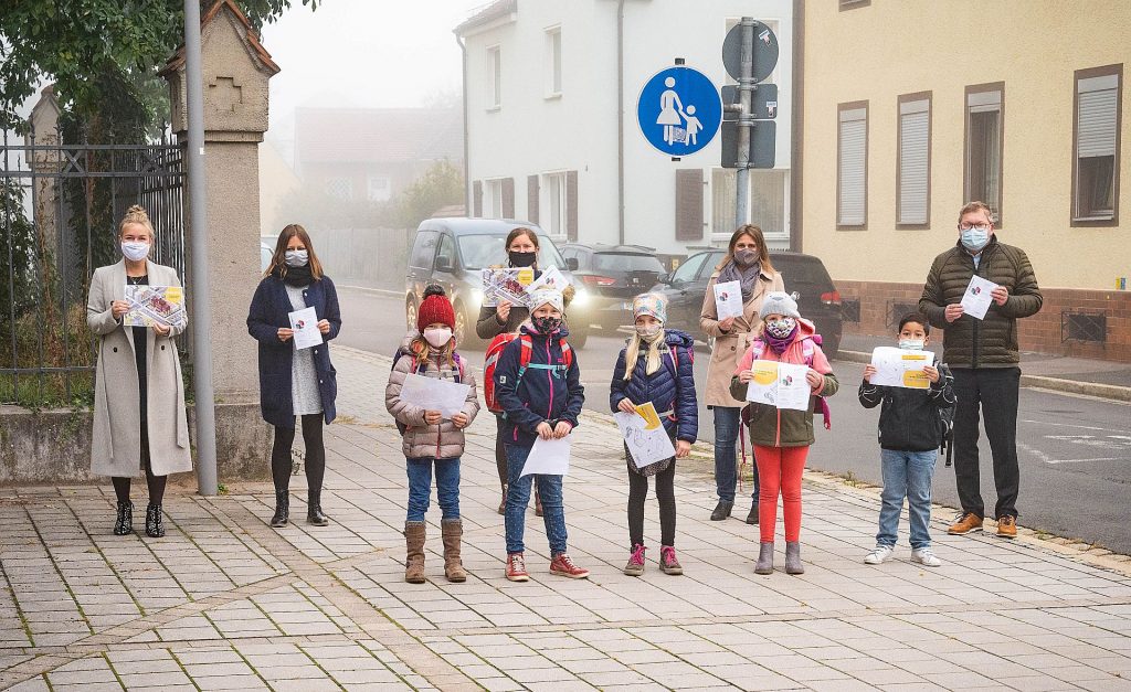 (von links nach rechts) Nadine Meier und Julia Rösch (Zweckverband Kommunale Verkehrssicherheit Oberpfalz), Corinna Loewert (Klimaschutzmanagerin Stadt Amberg), Silke Kick (Rektorin Max-Josef-Grundschule) sowie Oberbürgermeister Michael Cerny. Im Vordergrund fünf Schülerinnen und Schüler der Max-Josef-Grundschule mit Materialien der Aktion „Zu Fuß zur Schule“. Foto: Simon Wiesner, Stadt Amberg