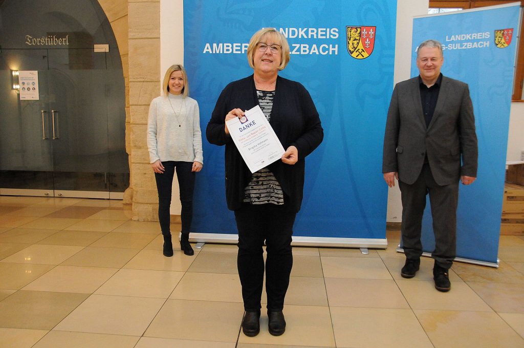 Am liebsten hätten Landrat Richard Reisinger und Linda Trager (li.) allen ehrenamtlichen Helfern die Dankurkunde persönlich überreicht, aber das lässt die Pandemie derzeit nicht zu. Deshalb bekam Brigitta Hofmann (Mitte) stellvertretend für alle Unterstützer die Urkunde überreicht. Foto: Christine Hollederer