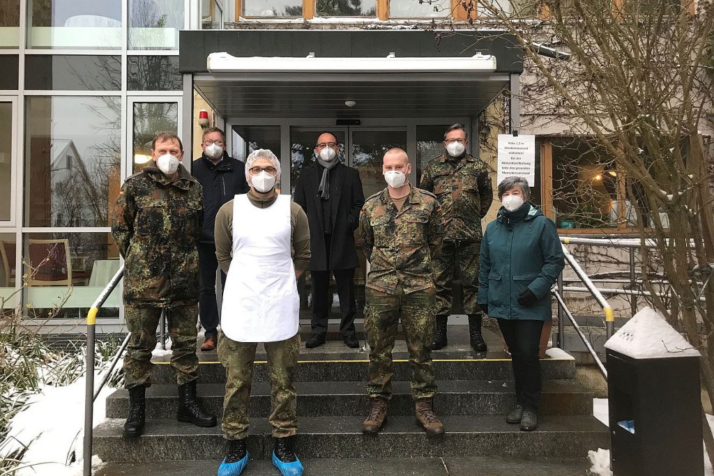 Hauptmann Anton Sertl, Oberbürgermeister Michael Cerny, Heimleiter Marcus Keil, Oberstleutnant Stephan Koller und die Pflegefachberaterin der Führungsgruppe Katastrophenschutz Birgit Hübner (hinten v.l.n.r.) mit den diensthabenden Soldaten vor dem Seniorenheim der Diakonie in der Hellstraße in Amberg Foto: Susanne Schwab, Stadt Amberg