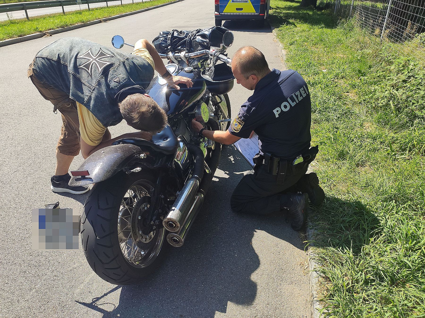 Bild: ein Biker wird durch einen Beamten der Kontrollgruppe Motorrad kontrolliert. Quelle: Marco Müller, PI Cham.