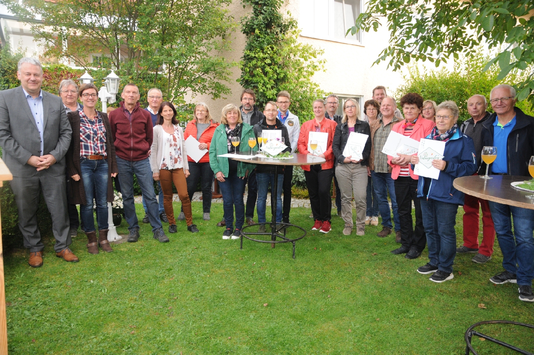 Landrat Richard Reisinger (links) und Kreisfachberaterin Michaela Basler (Dritte von links) überreichten in Mimbach im Garten Schmidt/Urbanek die Plaketten und Urkunden an die ersten ausgezeichneten Naturgarten-Besitzer des Landkreises. Foto: Joachim Gebhardt