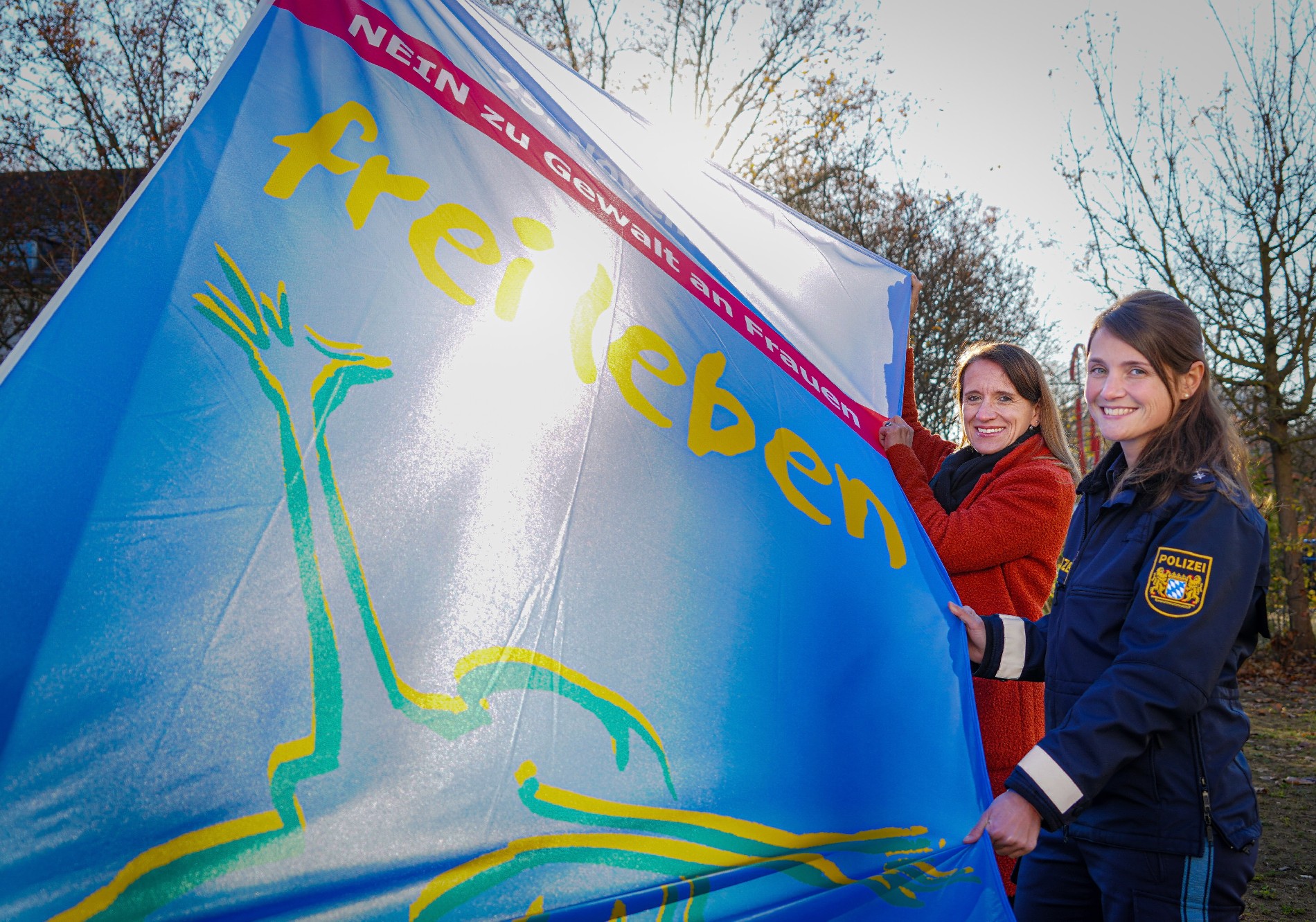 Polizeihauptkommissarin Andrea Meier (rechts) und die Beauftragte für Kriminalitätsopfer beim Polizeipräsidium Oberpfalz, Kriminalhauptkommissarin Barbara Arendt (links), hissten die Flagge „Frei leben ohne Gewalt“ vor dem Polizeipräsidium Foto: Polizeipräsidium Oberpfalz/tw