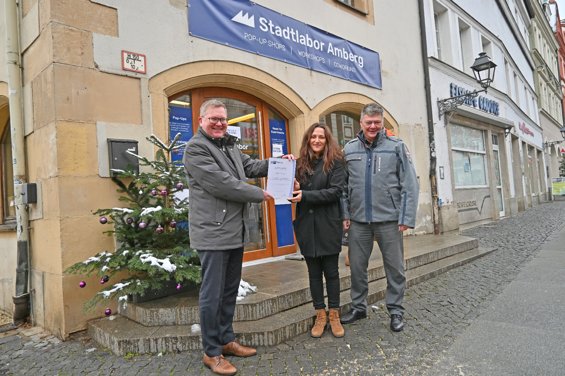 (von links): Oberbürgermeister Michael Cerny, Altstadtkümmerin Verena Fitzgerald und Geschäftsführer Karlheinz Brandelik freuen sich über die Auszeichnung. Foto © Thomas Graml, Stadt Amberg