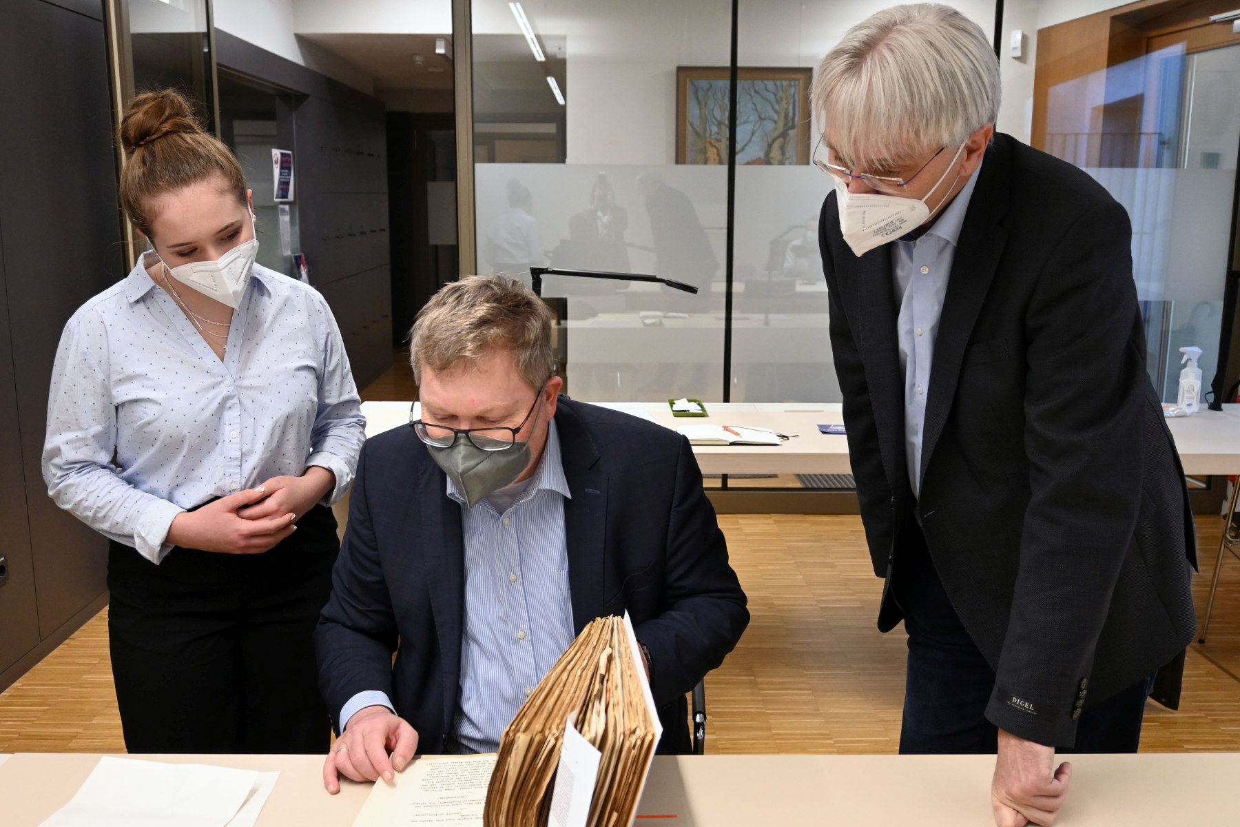 Oberbürgermeister Michael Cerny (Mitte) mit dem Leiter des Stadtarchivs Amberg (rechts) und Auszubildender Franziska Geißler bei der Durchsicht der Witzesammlung von Joachim Kubeng, die zusammen mit seinem weiteren Nachlass im Archiv aufbewahrt wird Foto: Susanne Schwab, Stadt Amberg