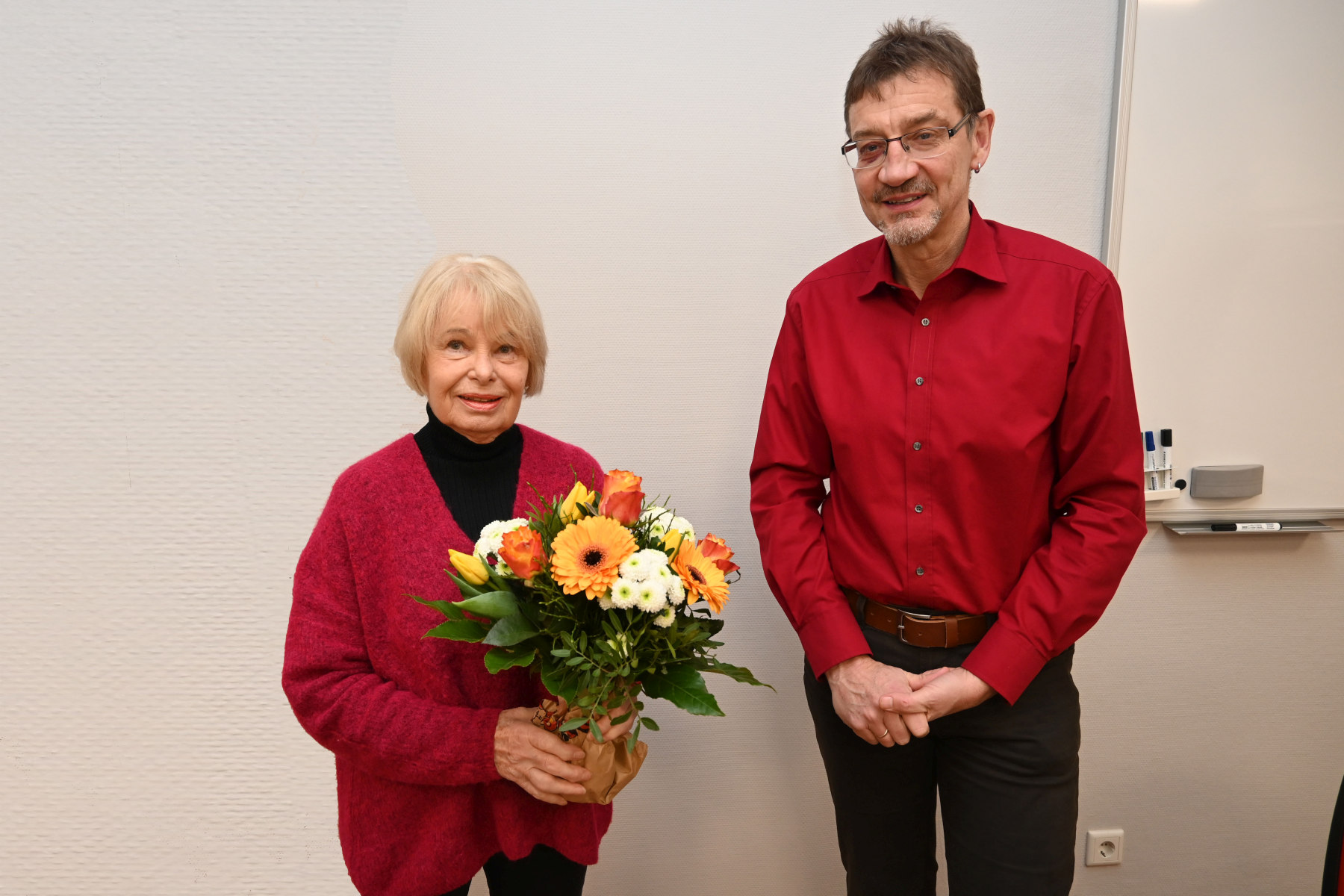 Gisela Schubert unterrichtet seit 50 Jahren Englisch an der Volkshochschule. VHS-Leiter Reiner Volkert gratuliert mit einem Blumenstrauß. Foto © Thomas Graml, Stadt Amberg