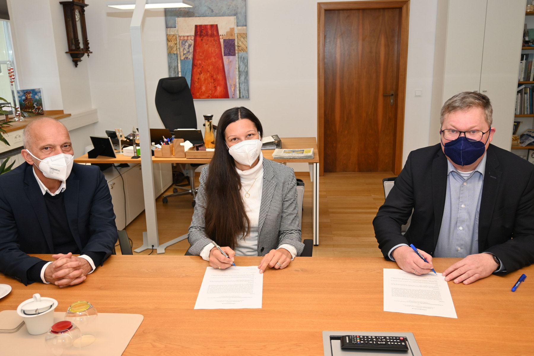 Die Leiterin der Regensburger Niederlassung der Firma Ten Brinke Sandra Kainz (Mitte) und Oberbürgermeister Michael Cerny (rechts) unterzeichnen im Beisein von Projektleiter Roand Seissler die Aufhebungsvereinbarung, nach der keinerlei offene Ansprüche der beiden Parteien mehr bestehen Foto: Susanne Schwab, Stadt Amberg