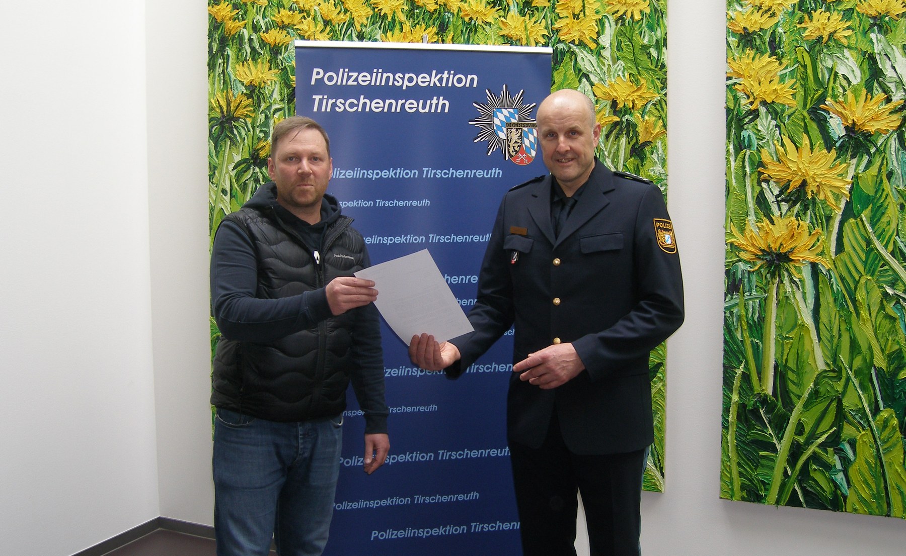 Der Leiter der Polizeiinspektion Tirschenreuth, EPHK Günther Burkhard (rechts im Bild) überreicht Herrn Diez (links im Bild) ein Anerkennungsschreiben des Polizeipräsidenten des Polizeipräsidium Oberpfalz.