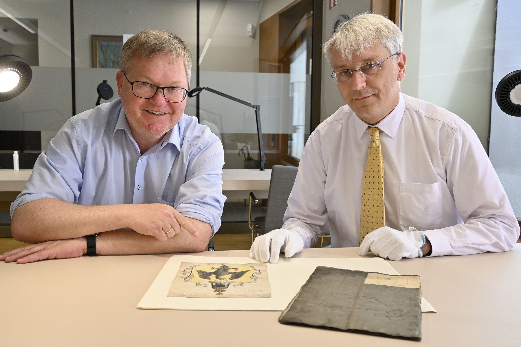 Stadtarchivar Dr. Andreas Erb (rechts) präsentiert Oberbürgermeister Michael Cerny das bei Inventarisierungsarbeiten gefundene Wappen der Tuchscherer Foto: Thomas Graml, Stadt Amberg