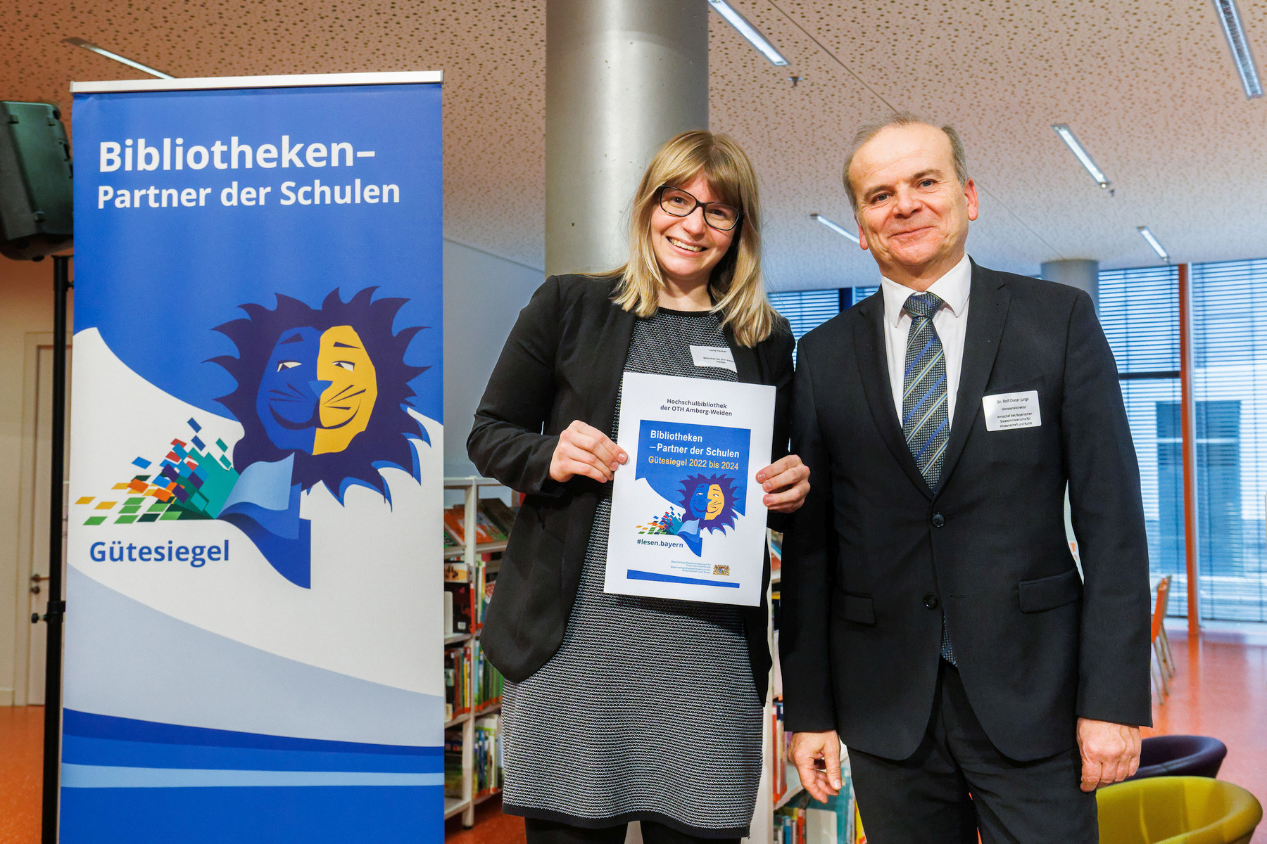 Lena Fischer, stellvertretende Bibliotheksleiterin der Hochschulbibliothek in Weiden, freut sich über das Zertifikat, übergeben von Ministerialdirektor Dr. Rolf-Dieter Jungk Foto: H.-R. Schulz/Bayerische Staatsbibliothek