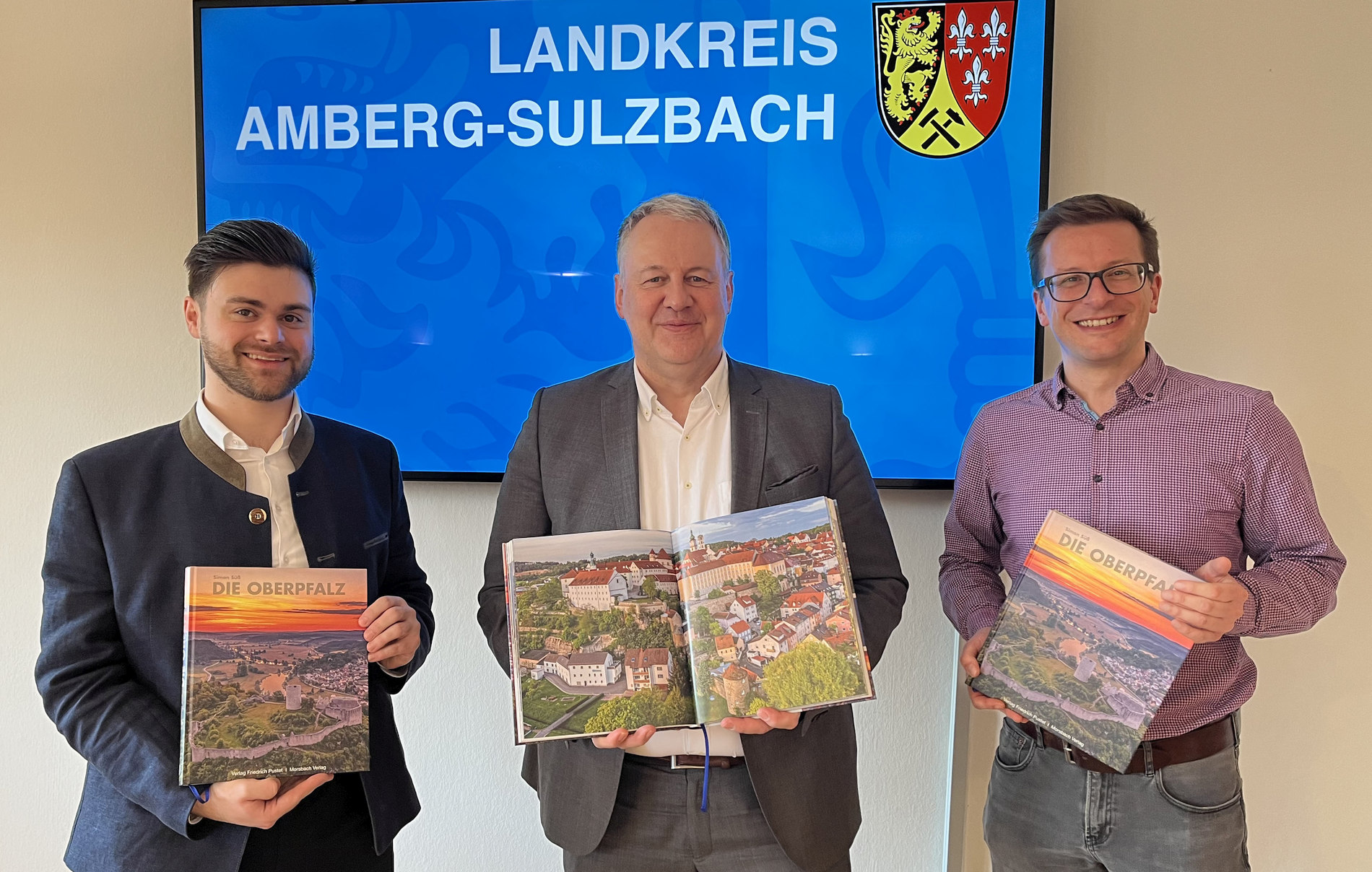 Vor allem das Bild seiner Heimatstadt Sulzbach-Rosenberg hat es Landrat Richard Reisinger angetan. Es ist eine von 250 Aufnahmen im neuen Bildband über die Oberpfalz, den Fotograf Simon Süß (links) an den Landrat sowie Tourismusreferent Hubert Zaremba (rechts) Foto: Christine Hollederer