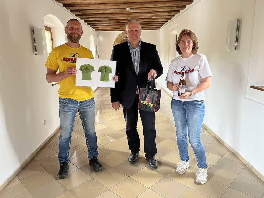 Andy Moser (links) und Alexandra Ottmann vom Schlackenverein baten Landrat Richard Reisinger erfolgreich um die Übernahme der Schirmherrschaft beim Schlackenlauf. Als wichtiges Argument hatten sie das spezielle Fuchsbeck-Bier dabei Foto: Christine Hollederer