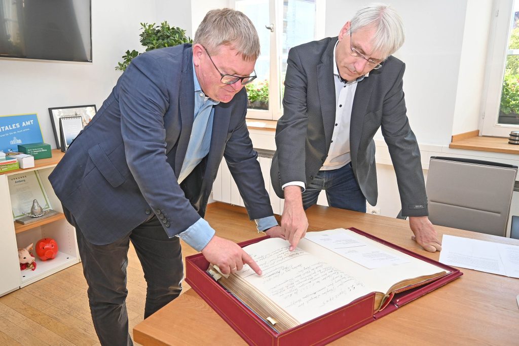 Oberbürgermeister Michael Cerny (links) und Stadtarchivar Dr. Andreas Erb blättern im Goldenen Buch der Stadt, dass heuer 100 Jahre alt wird. Foto © Thomas Graml, Stadt Amberg