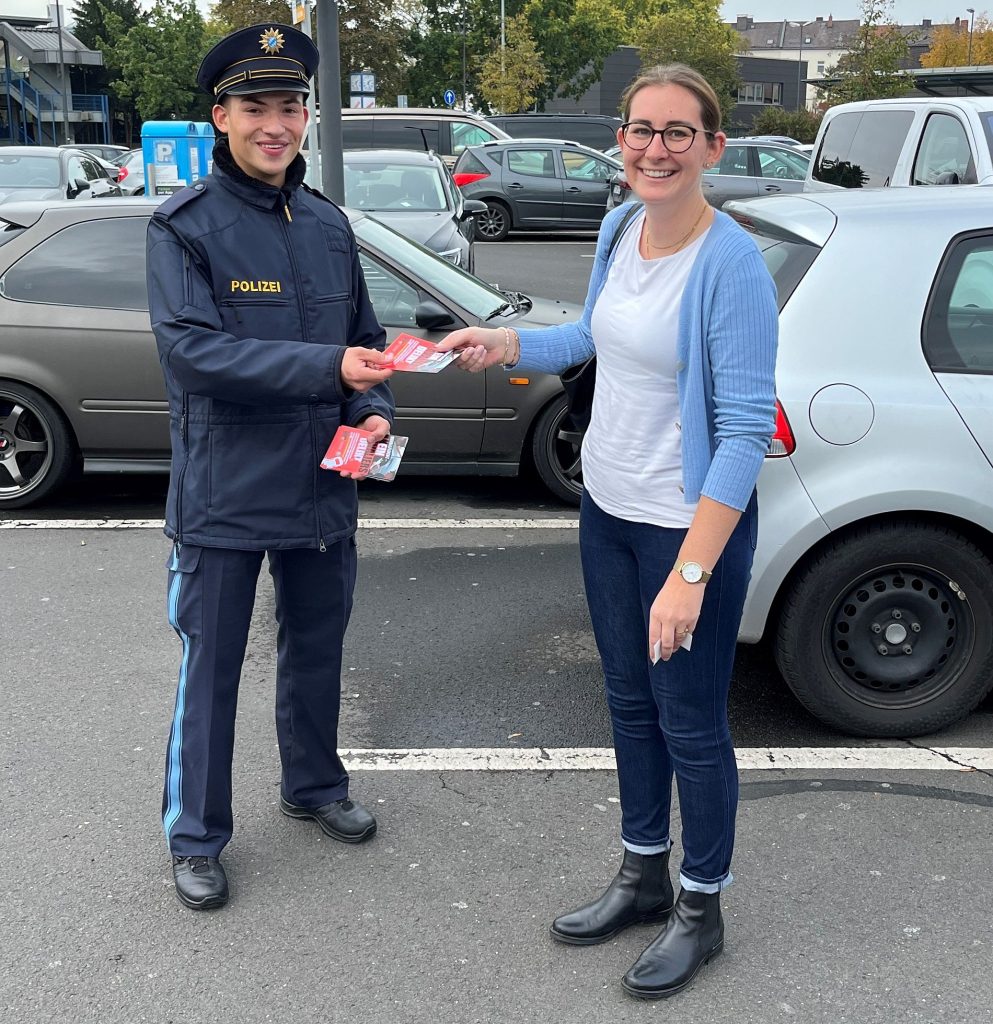 Ein Beamter in Ausbildung bei der Aushändigung eines Flyers an eine Verkehrsteilnehmerin Quelle: PI Weiden