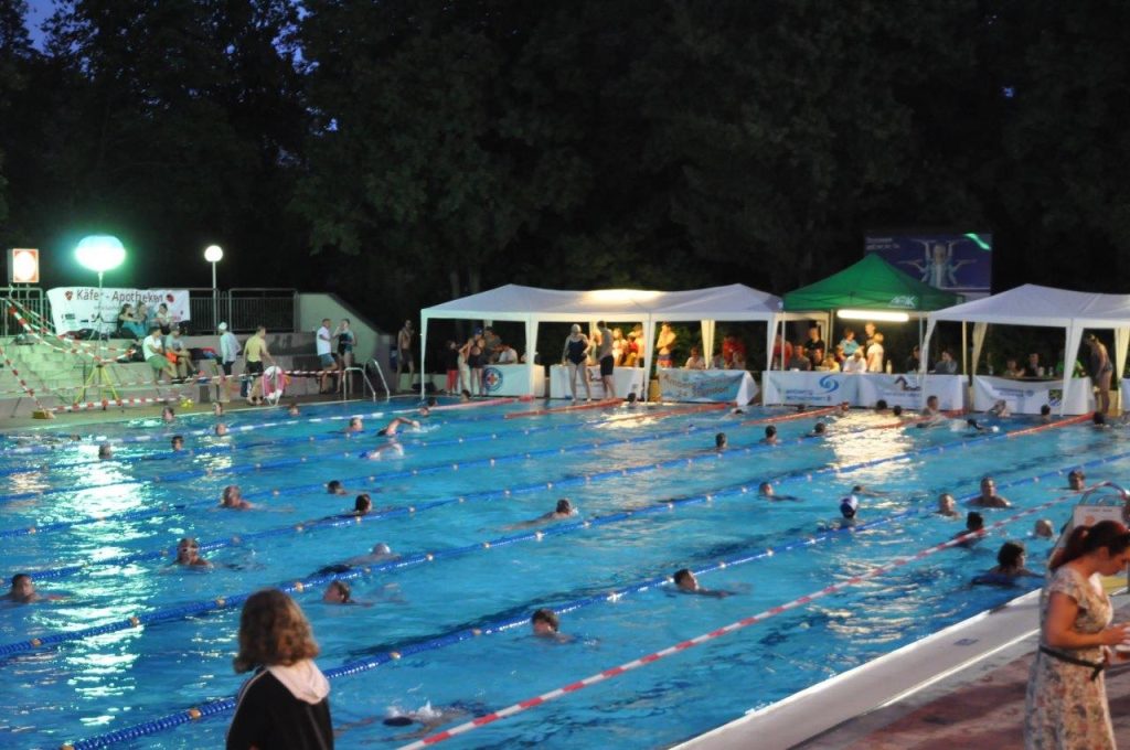 In diesem Jahr vom 19. bis 20. Juli 2024 von 09:00 bis 09:00 Uhr. Schwimmen rund um die Uhr für einen guten Zweck, das ist an dieser Veranstaltung die Devise. Der Eintritt ist während der ganzen Veranstaltung für Badegäste und Zuschauer frei. Die Bitte an alle vom Organisationsteam: „Machen Sie/ Macht mit!“. Die Becken sind, wie man hier sieht, auch nachts mit fleißigen und romantischen Schwimmern gefüllt. Aber es gibt noch mehr zusehen im Hockermühlbad- neuer Kinderspielplatz und mobile Textil-Sauna – das macht das Freibaden im Hocko noch mehr Spaß! Fotonachweis: Karoline Gajeck-Scheuck